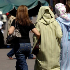Mujeres vestidas al uso occidental junto a otras con vestimentas tradicionales, en la plaza Jemaa El Fna, en Marraquech, en una imagen de archivo.
