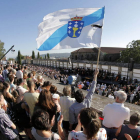 Una bandera gallega ondea durante el acto en recuerdo de los fallecidos y los heridos.