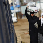 Refugiados sirios trasladan bolsas de alimentos en el paso fronterizo de Öncüpinar, en Kilis, Turquía.
