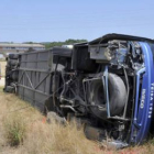 El autocar volcó fuera de la carretera tras caer por una pendiente de dos metros.