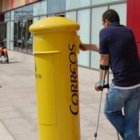 Una persona deposita una carta en el buzón ubicado al lado del centro de discapacitados.