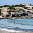 Dos personas se bañan en la playa de ses Illetes en Formentera.