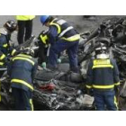 Los bomberos inspeccionan uno de los coches localizado bajo los escombros