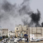Una columna de humo se eleva del lugar donde se ha producido un bombardeo en la capital de Yemen.