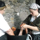 Dos mujeres elaboran embutidos a la manera tradicional.