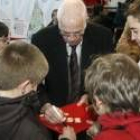 Aragonés  firma autógrafos durante un encuentro  con niños en la Ciudad del Fútbol de Las Rozas