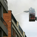 Un bombero trabaja en la extinción del incendio en la Avenida de San Mamés.