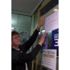 La titular de la administración cacabelense, colocando el cartel del premio