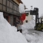 Un vecino retira a paladas la nieve acumulada en la puerta de su casa, ayer, en Lario.