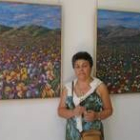 La autora posa junto a algunas de sus obras pictóricas