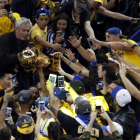 Stephen Curry alza el trofeo de la NBA.