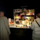 Dos personas se acercan a uno de los puestos de la Feria del Libro