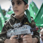 Un niño palestino en brazos de su padre participa en la manifestación a favor de Hamas en la franja.