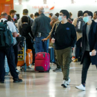 Viajeros protegidos con mascarillas el 12 de marzo en el aeropuerto Madrid. EMILIO NARANJO