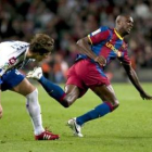 Eric Abidal, a la derecha, cae ante la entrada del mediocentro del Deportivo Rubén Pérez.