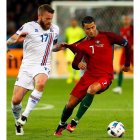 Cristiano Ronaldo lucha por el balón con Aron Gunnarsson. ROBERT GHEMENT