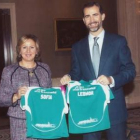 Sagrario González entrega al Príncipe las dos camisetas personalizadas para Leonor y Sofía.