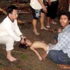 El cuerpo de una niña víctima del tsunami yace en el suelo junto a unos vecinos en Pangandaran