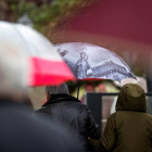 Varias personas se protegen del frío y la lluvia