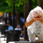 Una mujer se refresca en una fuente de  debido al calor sofocante más propio del mes de julio. SALAS