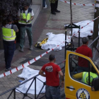 Los cadáveres del triple crimen, en la calle a la espera de que sean trasladados por los servicios funerarios.