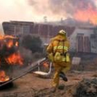 Un bombero corre para intentar sofocar las llamas que rodean una casa móvil, ayer en Los Ángeles
