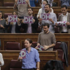 Diputados de Podemos muestran carteles a favor de los derechos humanos al inicio del pleno del Congreso.