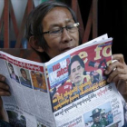 Un birmano lee un periódico donde Suu Kyi aparece en portada, este sábado.