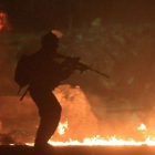 Un soldado israelí pasa entre neumáticos en llama, durante las protestas palestinas contra Israel, ayer en la franja de Gaza.