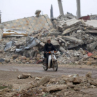 Un hombre circula en moto por los alrededores de Alepo.
