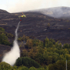 Un helicóptero trabaja en la extinción del incendio de Forna, que dejó un paisaje de desolación.