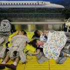 Tres niñas duermen en una estación por la cancelación de vuelos domésticos debido a la llegada del tifón Man-yi.