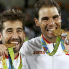 Marc López y Rafael Nadal muerden las medallas de oro.