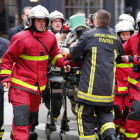Bomberos y personal sanitario transportan a uno de los muchos heridos que provocó la explosión de la panadería parisina. IAN LANGSDON