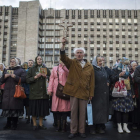Varias personas rezan por la paz junto a un edificio gubernamental ocupado, en Donetsk.