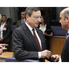 El ministro de Economía, Luis de Guindos, conversa en la reunión del Eurogrupo con el presidente del Banco Central Europeo, Mario Draghi.
