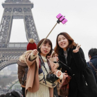 Un grupo de turistas orientales ante la Torre Eiffel.