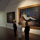 Imagen de tres piezas de Enrique Marty ante una de las obras del museo Castagnino de Rosario.