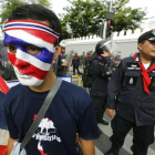 Un manifestante lleva una máscara con los colores de la bandera tailandesa durante la manifestación convocada en los alrededores del Parlamento en Bangkok.
