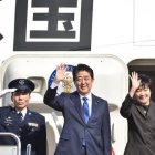 Abe (segundo por la izquierda) y su esposa, Akie, saludan antes de embarcarse en el avión hacia EEUU, en el aeropuerto de Haneda (Tokio), este jueves.
