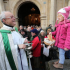 El párroco de Cacabelos, Jesús ÁLvarez, bendice el pan que lleva una niña