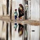 Una mujer lleva a sus hijos a casa en el barrio de Al Sáder, en Bagdad