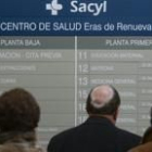 Usuarios del centro de salud de Eras de Renueva se orientan ante un panel informativo