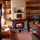 Salón con chimenea y fachada dela casa rural Los Cerezos, en el pueblo berciano de Rimor.