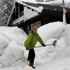 Una mujer aparta la nieve en Val DIsere, en los Alpes franceses.