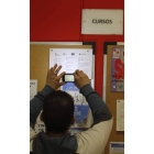 Un joven fotografía un panel del INEM.