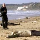 Dos guardias civiles custodian dos de los cadáveres aparecidos ayer en la costa de Rota