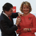 El presidente de la Comunidad madrileña coloca a Aguirre una de las medallas de Oro.