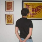 Un joven observa varias obras de Jaime Quintana.