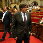 El presidente de la Generalitat, Carles Puigdemont (d) y el vicepresidente del Govern, Oriol Junqueras (i), abandonan el hemiciclo del Parlament de Cataluña.